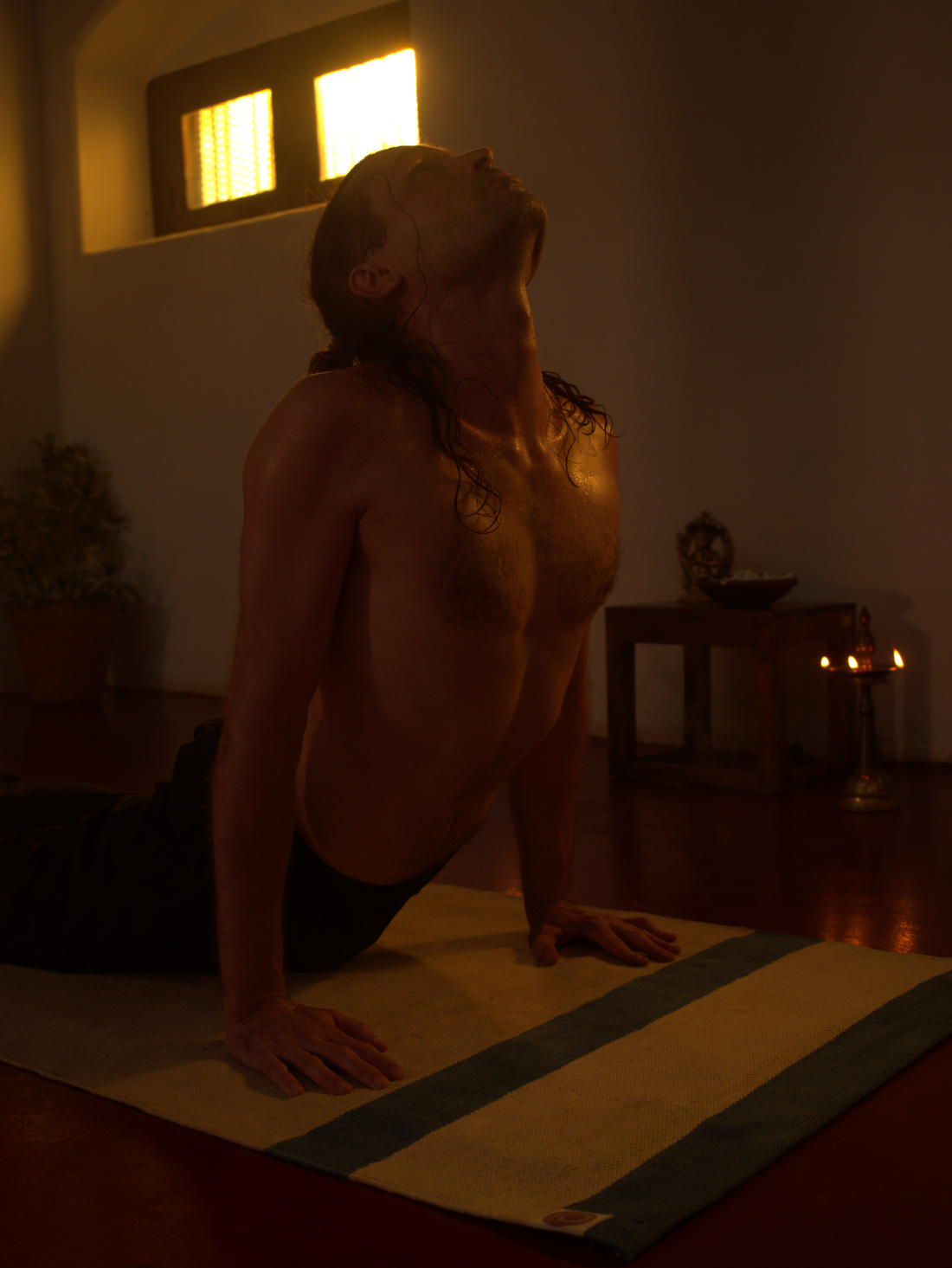 Upward facing dog - young man practicing yoga on organic cotton yoga mat